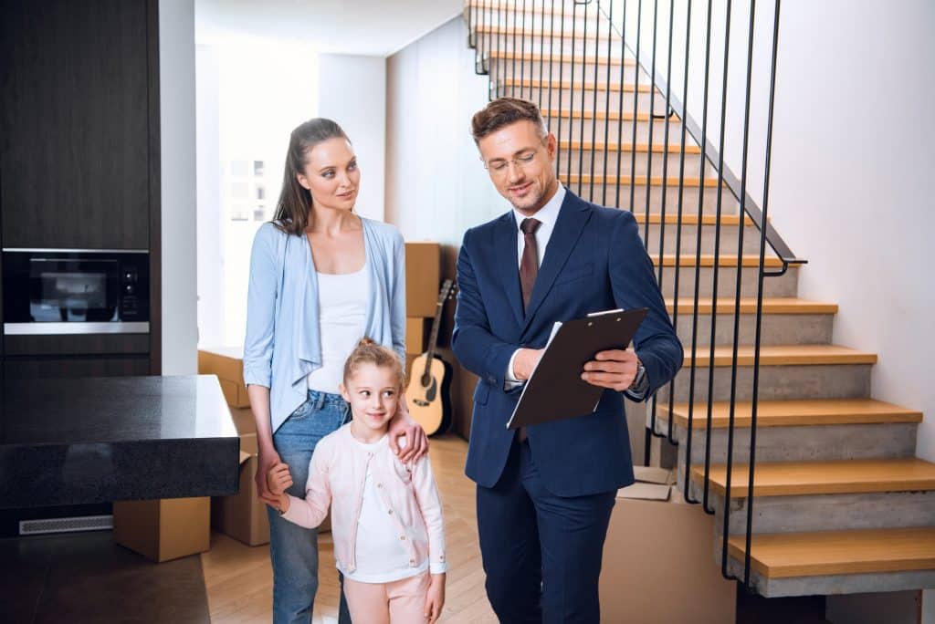 attractive woman standing with daughter and looking at broker